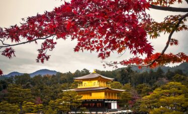 Stunning view of Kinkaku-ji temple reflecting in the waters surrounded by autumn foliage in Kyoto, Japan.