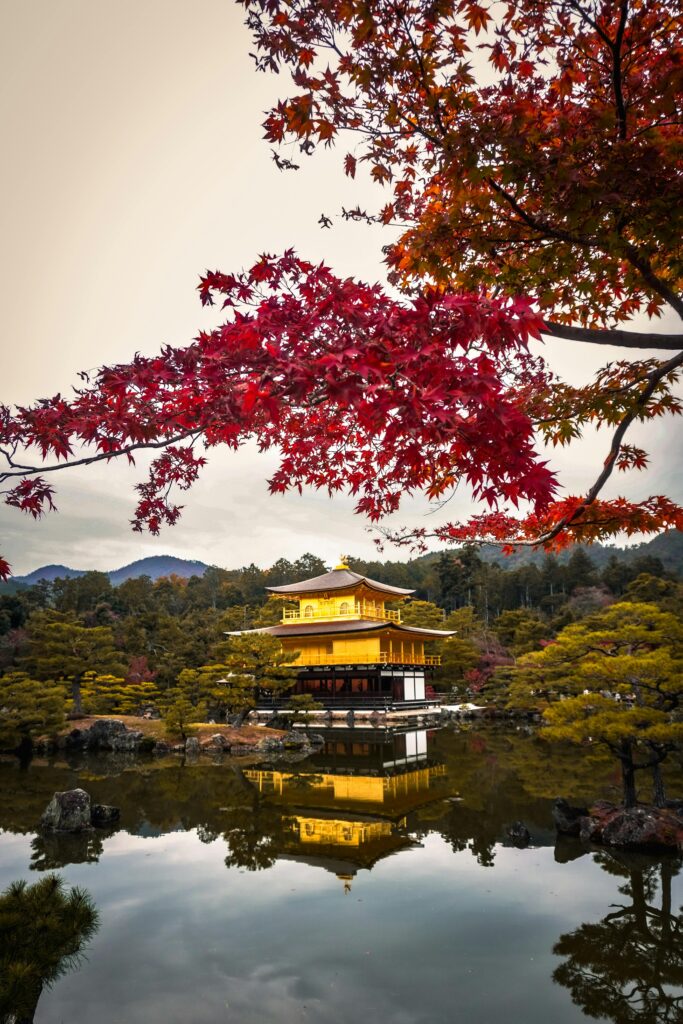 Stunning view of Kinkaku-ji temple reflecting in the waters surrounded by autumn foliage in Kyoto, Japan.