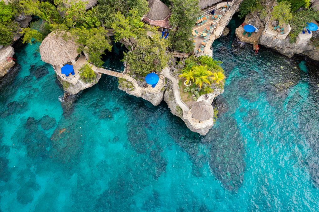 Stunning aerial view of a cliffside resort in Negril, Jamaica, featuring turquoise waters and natural architecture.