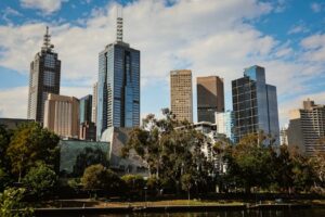 Stunning daytime view of Melbourne's modern skyline with high-rise buildings and lush greenery.