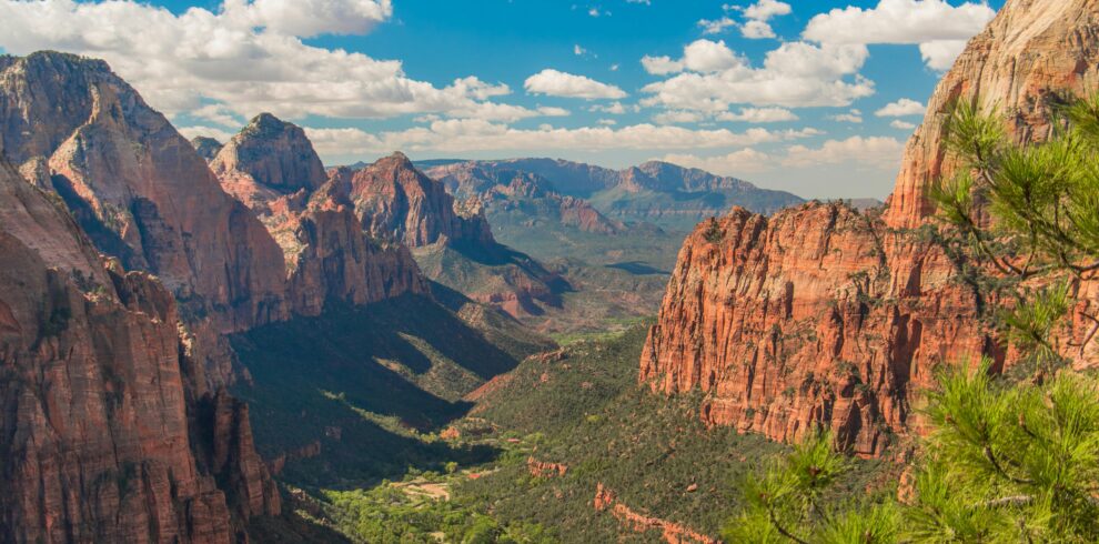 Stunning aerial view of Zion National Park showcasing red cliffs, lush valley, and blue skies.
