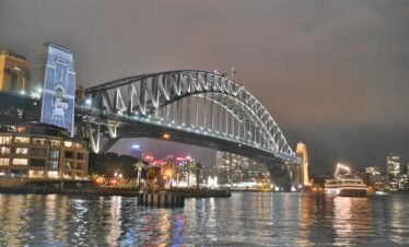 Stunning night view of the illuminated Sydney Harbour Bridge reflecting in the water.