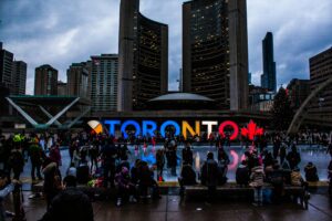 Vibrant evening at Toronto City Hall with festive crowd enjoying the cityscape.