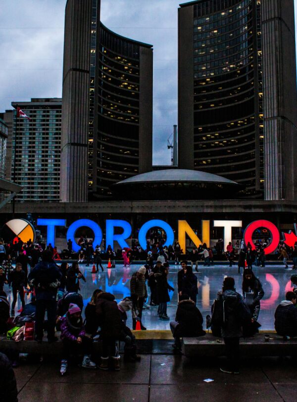 Vibrant evening at Toronto City Hall with festive crowd enjoying the cityscape.